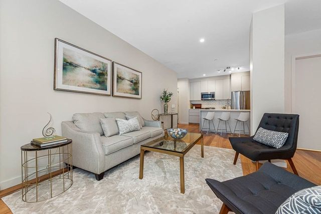 a living room with furniture and a view of kitchen