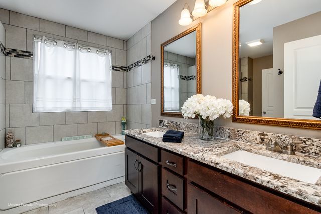 103 South Cranberry Street Bolingbrook, IL 60490 - Photo 17 of 33 a bathroom with a granite countertop tub sink and mirror