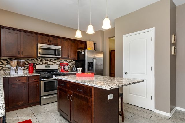 103 South Cranberry Street Bolingbrook, IL 60490 - Photo 7 of 33 a kitchen with stainless steel appliances granite countertop a stove microwave and refrigerator