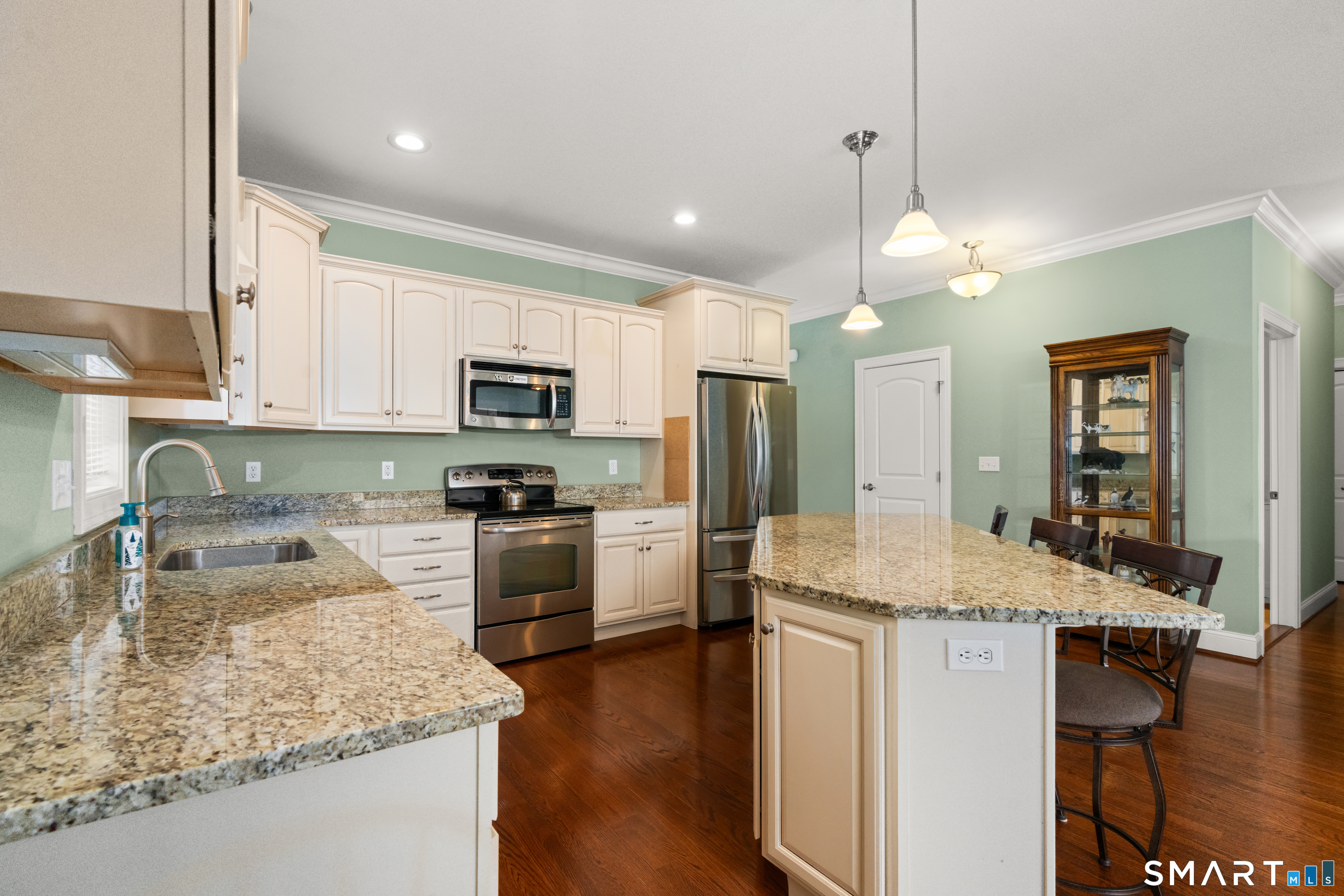 24 Center Court, Unit 24 Colchester, CT 06415 - Photo 8 of 36 a kitchen with kitchen island granite countertop stainless steel appliances a sink stove refrigerator and cabinets