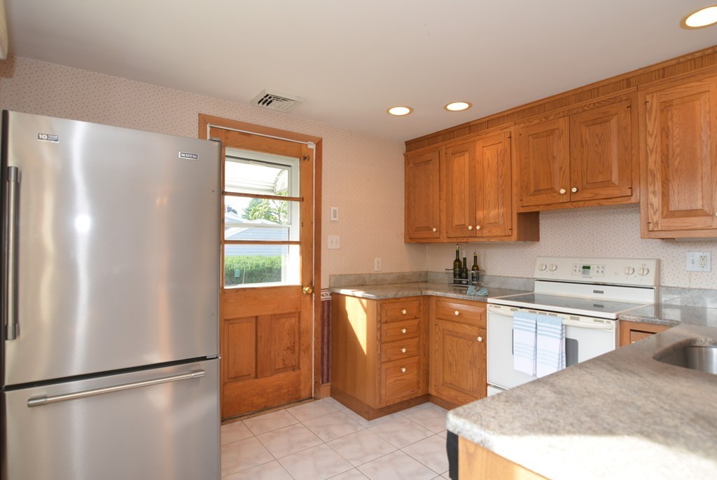 6 Cardinal Road Stoneham, MA 02180 - Photo 8 of 27 a kitchen with stainless steel appliances granite countertop a refrigerator sink and cabinets