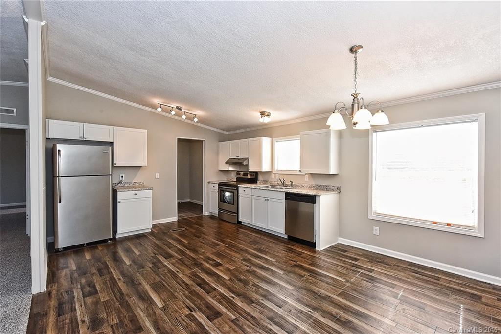 6815 Lackey Road, Unit 1 Vale, NC 28168 - Photo 6 of 24 a kitchen with stainless steel appliances granite countertop a refrigerator a sink dishwasher a stove and white countertops with wooden floor