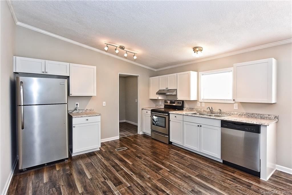 6815 Lackey Road, Unit 1 Vale, NC 28168 - Photo 7 of 24 a kitchen with stainless steel appliances granite countertop a refrigerator a sink dishwasher a stove and white countertops with wooden floor