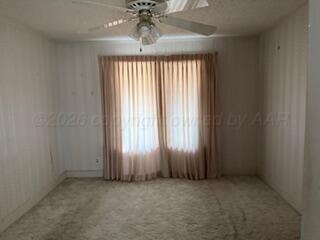 5204 Albert Avenue Amarillo, TX 79106 - Photo 8 of 17 an empty room with a chandelier fan and windows