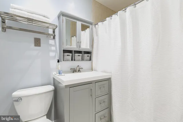 a bathroom with a sink a toilet and a mirror