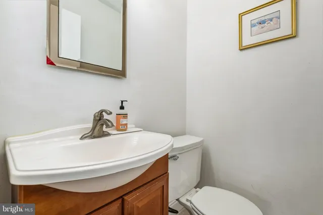 a bathroom with a toilet a sink and mirror