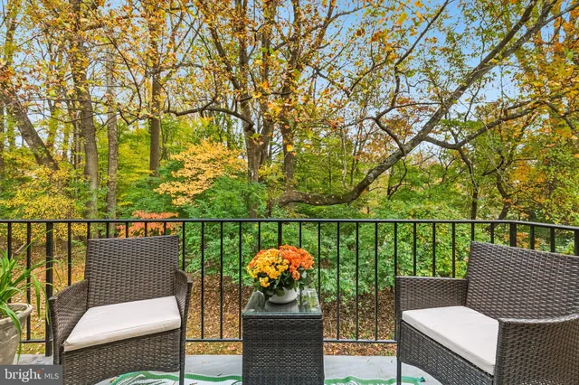 a balcony with wooden floor table and chairs