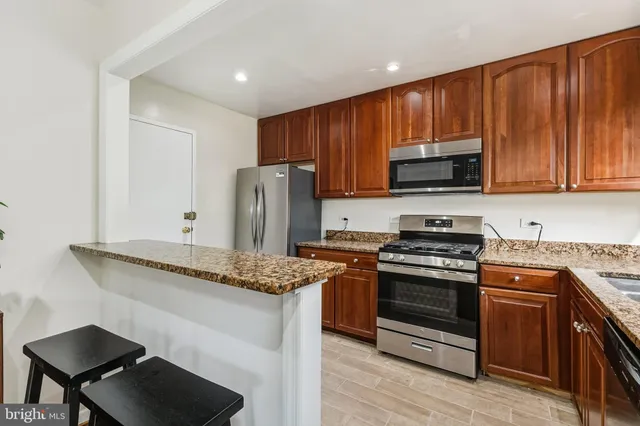 a kitchen with stainless steel appliances granite countertop a stove a refrigerator and a microwave