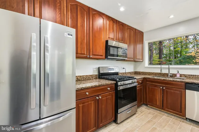 a kitchen with stainless steel appliances granite countertop a stove a refrigerator and a sink
