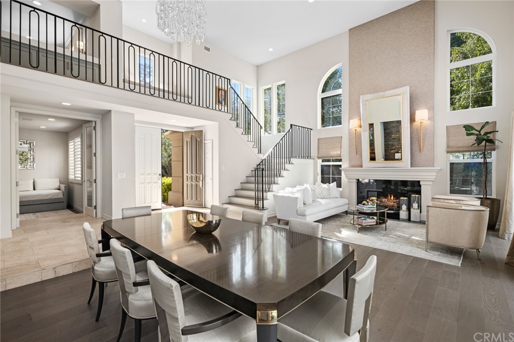 a living room with fireplace a dining table and chairs