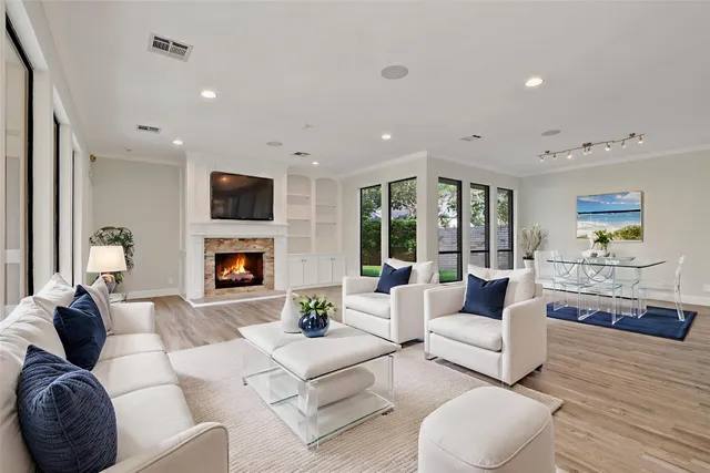 a view of an empty room with wooden floor fireplace and a window