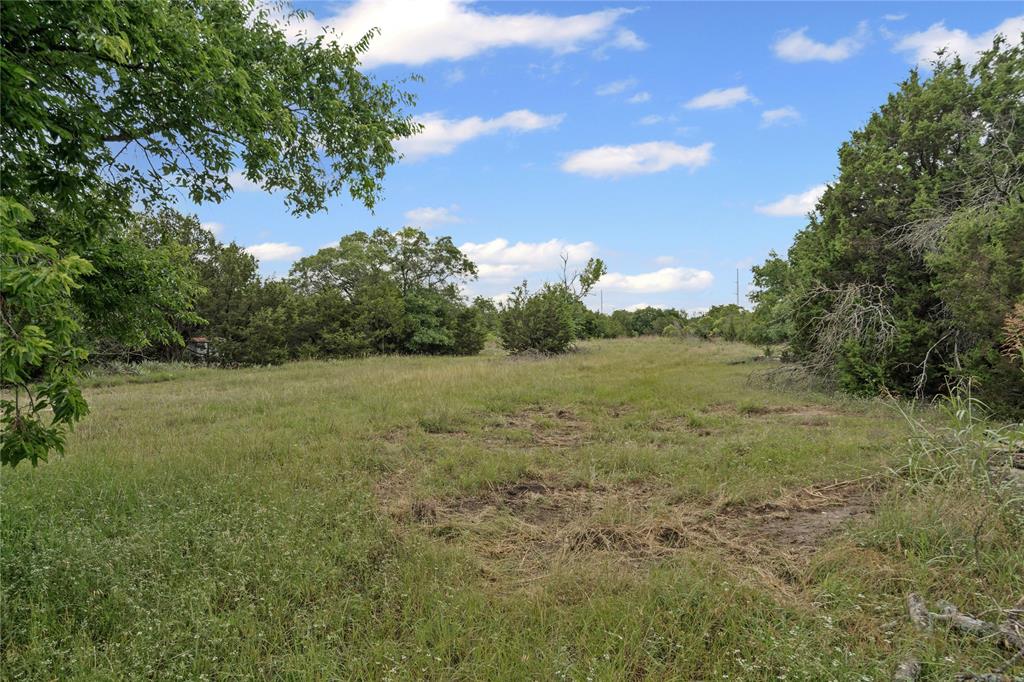 905 Zion Hill Road, Unit B Weatherford, TX 76088 - Photo 7 of 23 a view of a field with an trees in the background