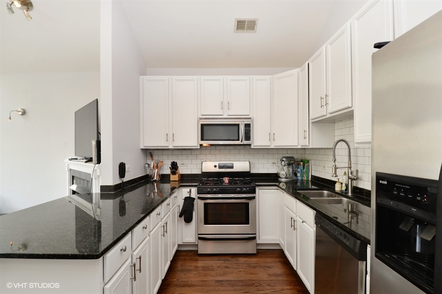 2508 West Division Street, Unit 3 Chicago, IL 60622 - Photo 5 of 10 a kitchen with stainless steel appliances granite countertop a stove top oven a sink and dishwasher