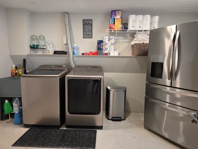 a kitchen with stainless steel appliances a refrigerator a sink a stove and a refrigerator