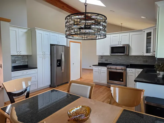 a kitchen with stainless steel appliances granite countertop a stove refrigerator and microwave