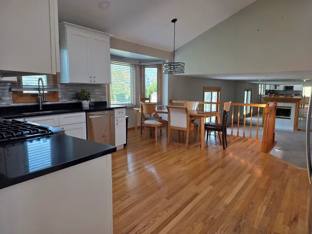 a kitchen with stainless steel appliances granite countertop wooden floors a stove and a granite counter top