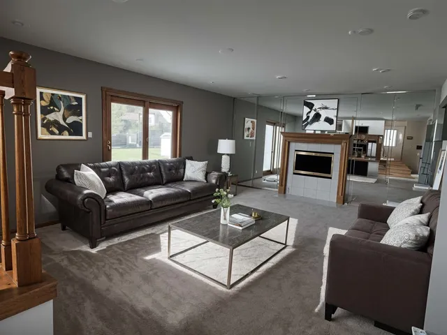 a living room with furniture a fireplace and a window