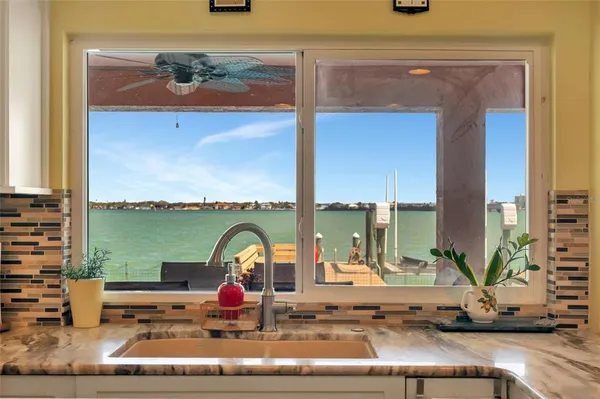 a view of a lake with a yard and large trees