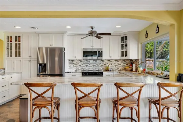a spacious bedroom with a bed a dresser and a window