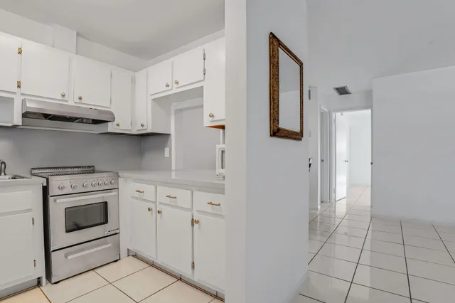 a kitchen with white cabinets and white appliances