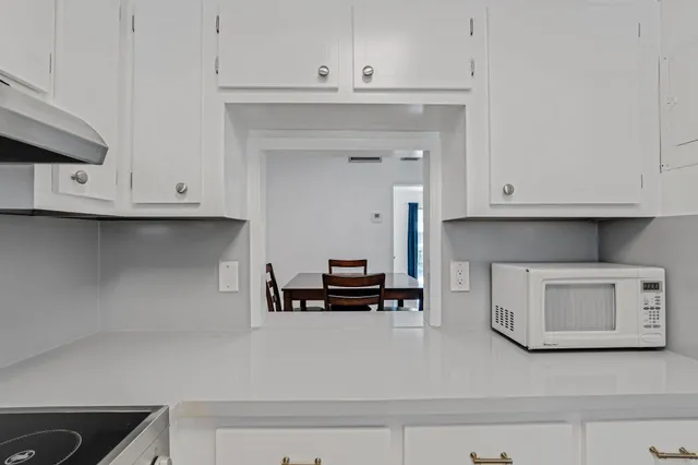 a kitchen with white cabinets and a stove