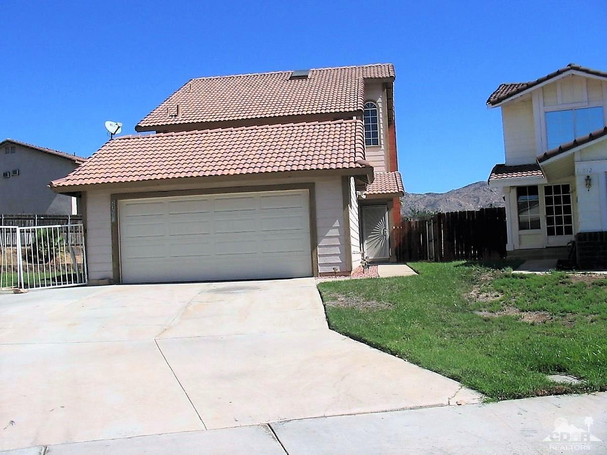 23680 Blooming Meadow Road Moreno Valley, CA 92557 - Photo 1 of 22 a front view of a house with a garden