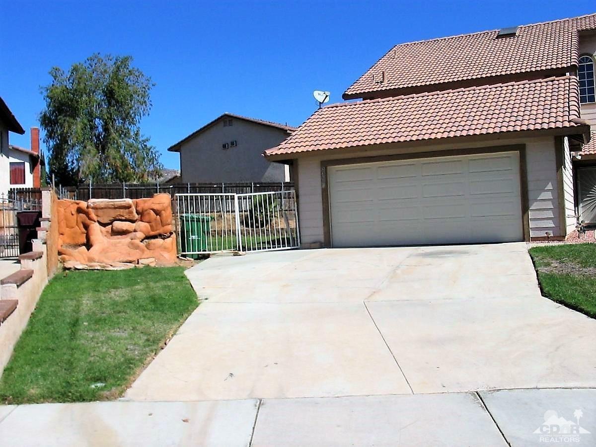 23680 Blooming Meadow Road Moreno Valley, CA 92557 - Photo 2 of 22 a front view of a house with a yard