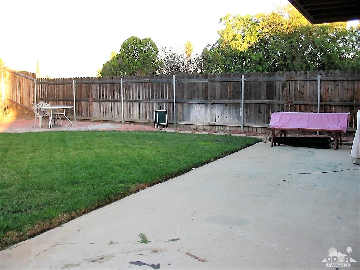 23680 Blooming Meadow Road Moreno Valley, CA 92557 - Photo 12 of 22 a view of a backyard with a small cabin and a chair