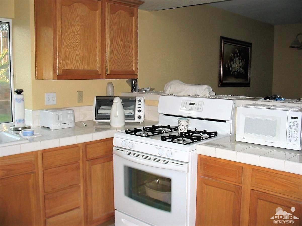 23680 Blooming Meadow Road Moreno Valley, CA 92557 - Photo 13 of 22 a kitchen with a stove and a sink