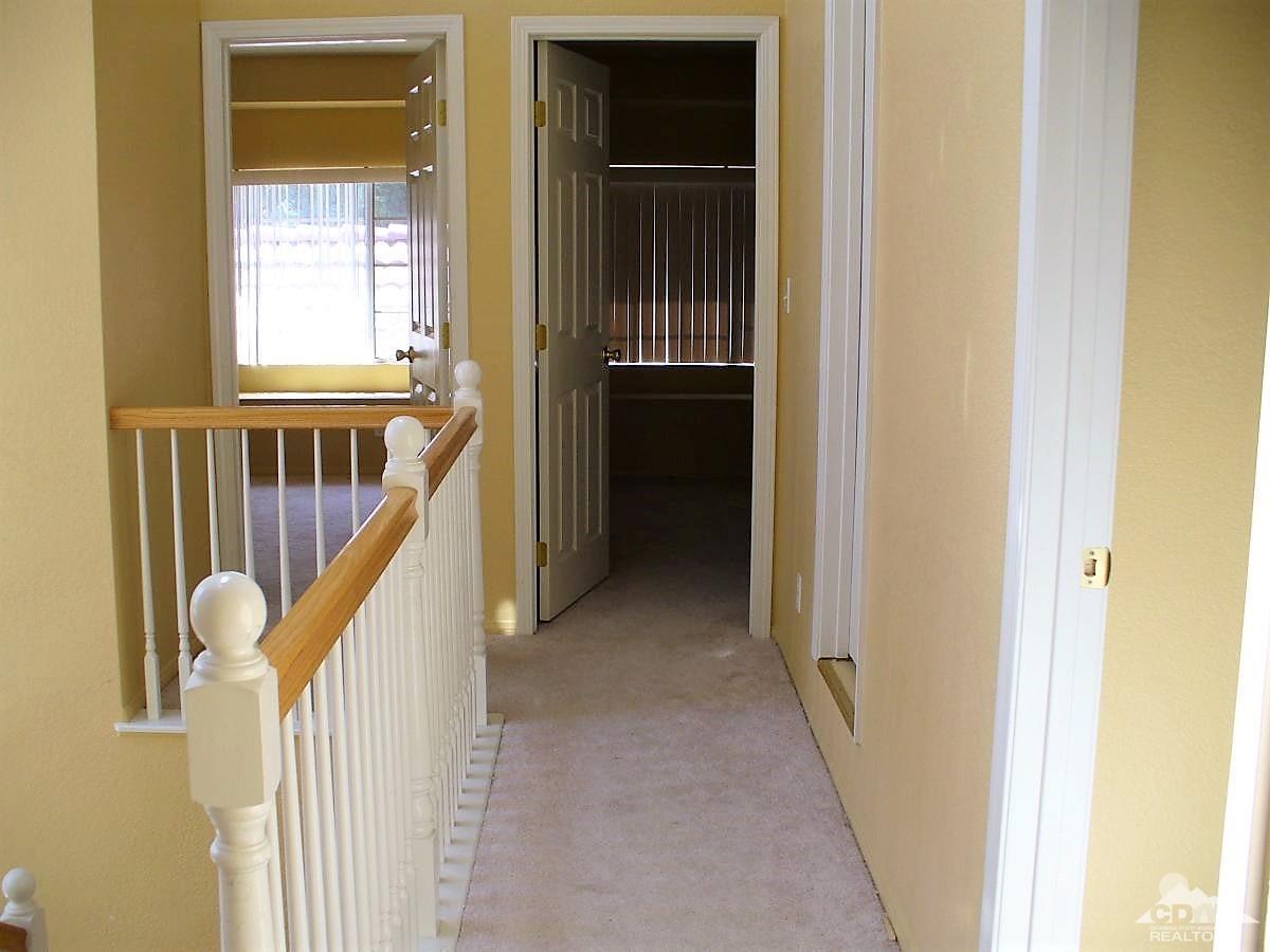23680 Blooming Meadow Road Moreno Valley, CA 92557 - Photo 8 of 22 a view of a hallway with wooden floor and stairs