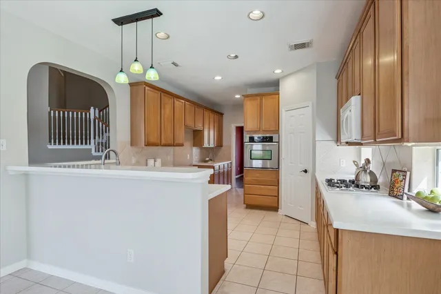 a kitchen with stainless steel appliances granite countertop a sink a stove and a refrigerator