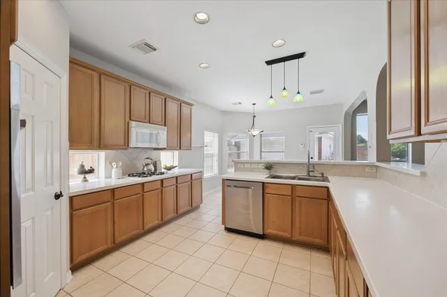 a large kitchen with cabinets a sink and a stove