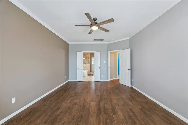 a view of an empty room with window and wooden floor