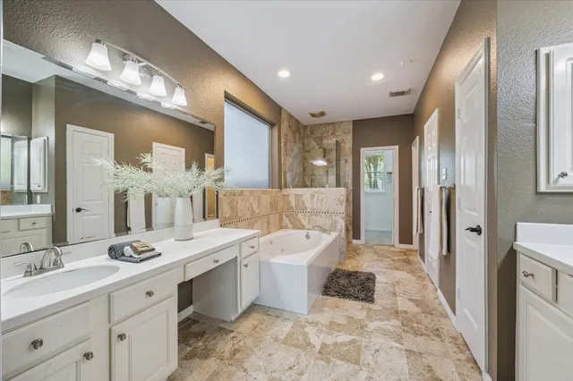 a large bathroom with a double vanity sink a large mirror and a shower