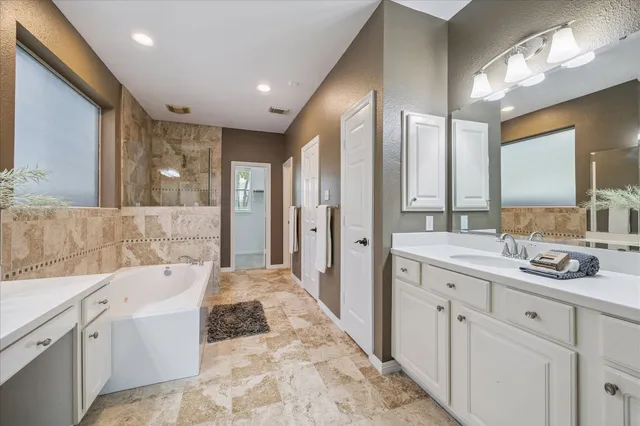a bathroom with a tub sink and mirror