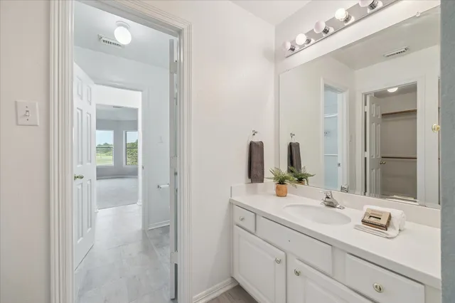 a bathroom with a sink vanity and mirror