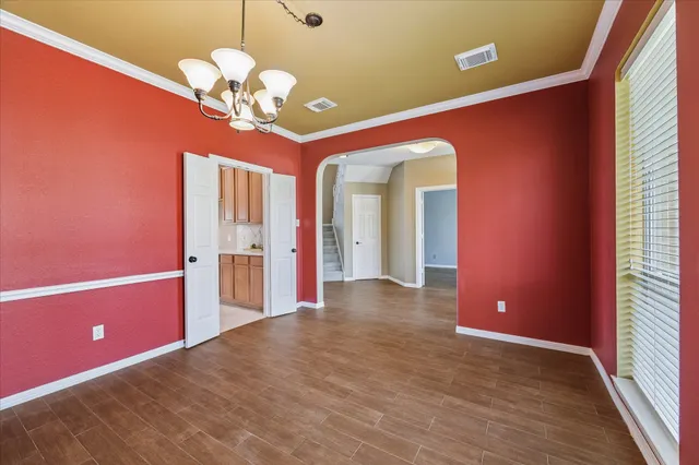 a view of a livingroom with a chandelier fan and windows