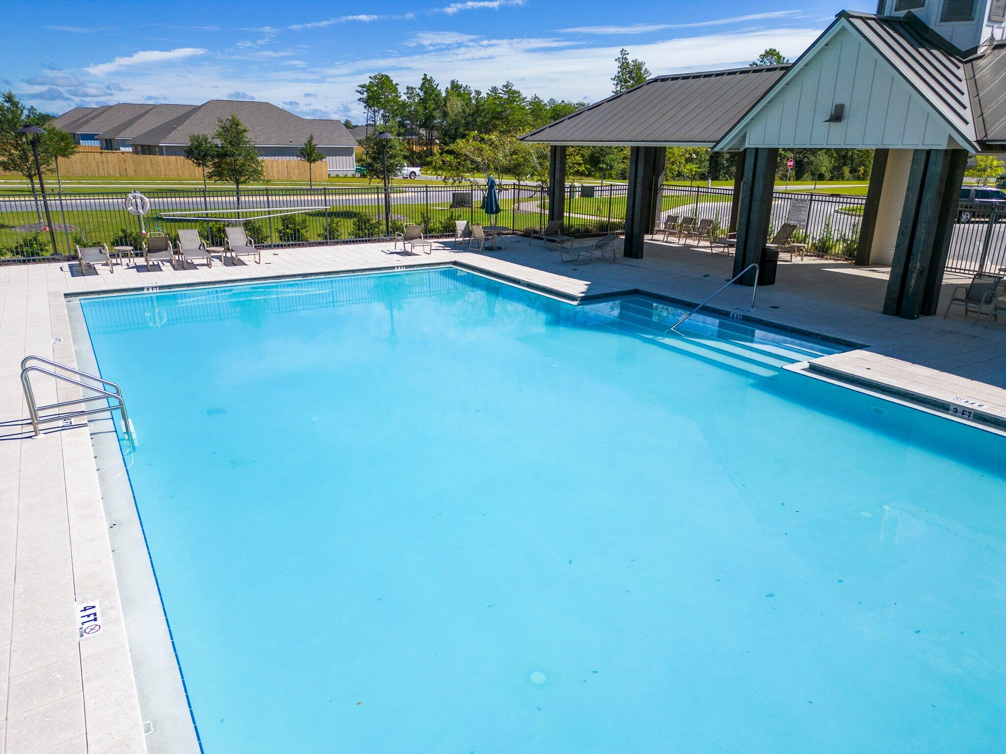 810 Otto Loop Crestview, FL 32539 - Photo 41 of 41 a view of swimming pool with a table and chairs under an umbrella