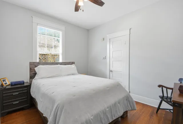 a bedroom with a bed and wooden floor