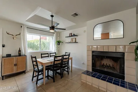 a dining room with furniture a fireplace and a chandelier