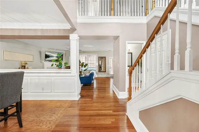 a view of an entryway with wooden floor and a kitchen view