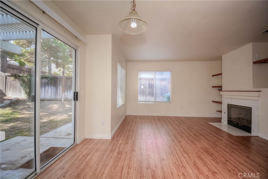 554 Pointe Vista Court Corona, CA 92881 - Photo 14 of 31 an empty room with wooden floor fireplace and windows