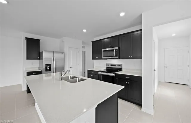 a kitchen with kitchen island a sink appliances and cabinets