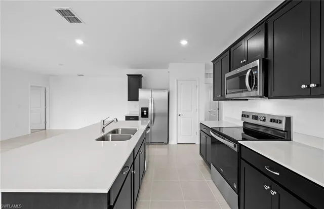 a kitchen that has a sink and a stove top oven