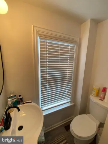 a bathroom with a sink a toilet and a mirror