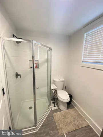 a bathroom with a toilet and a shower