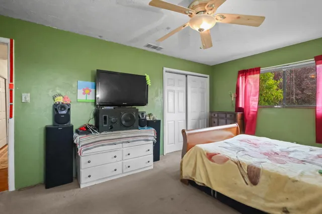 a bedroom with a bed and a flat screen tv
