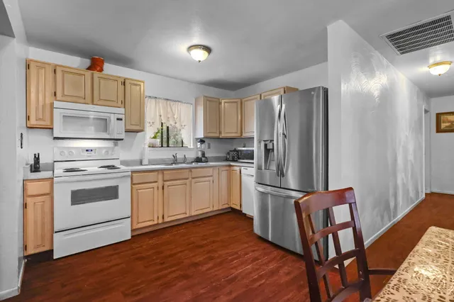 a kitchen with granite countertop a refrigerator stove and sink