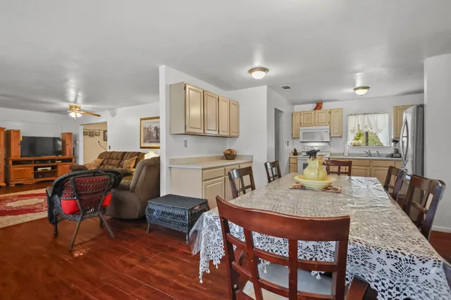 a living room with stainless steel appliances furniture a couch and a kitchen view