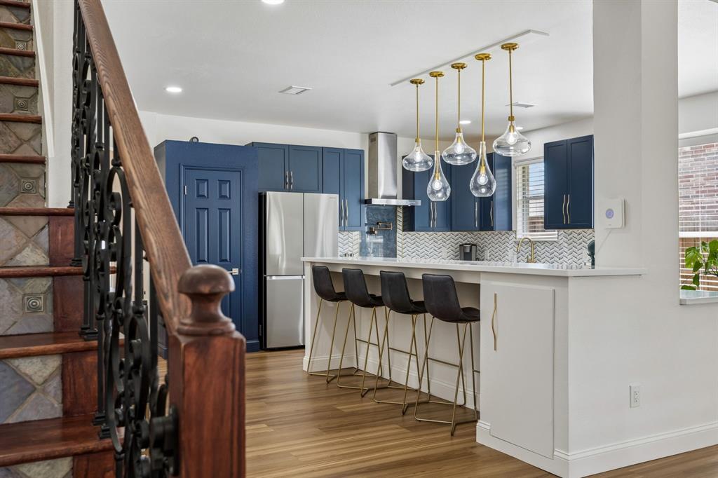 9217 Inverness Drive Rowlett, TX 75089 - Photo 15 of 40 Kitchen Breakfast Bar — The long breakfast bar adds everyday seating and serving space, while the updated kitchen finishes create a polished focal point near the heart of the home.